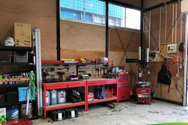 赤い工具箱とボール盤のある作業場