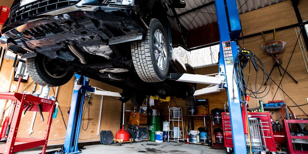 リフトで車を上げて作業する工場の中